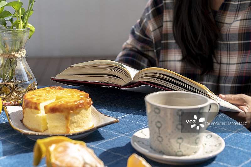 下午茶：咖啡、奶酪蛋糕和阅读书籍图片素材