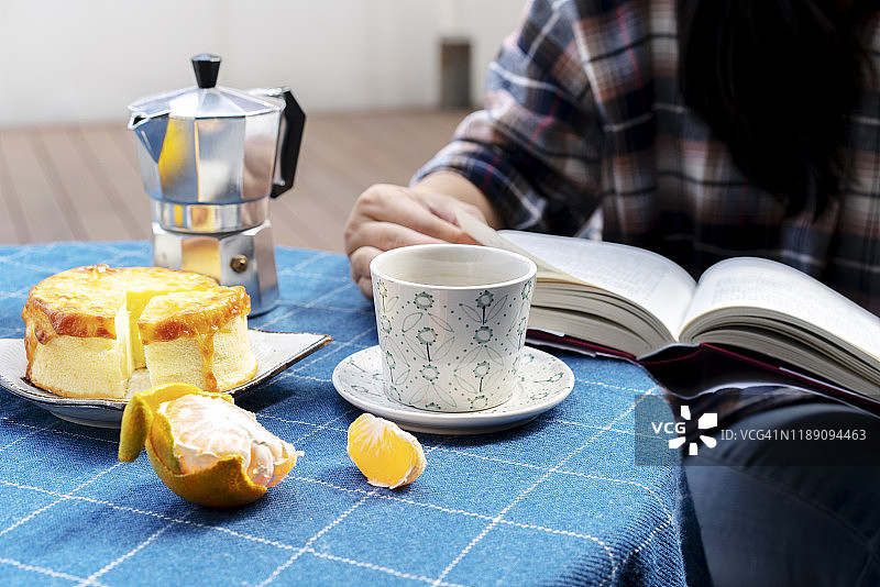 下午茶：咖啡、奶酪蛋糕和阅读书籍图片素材