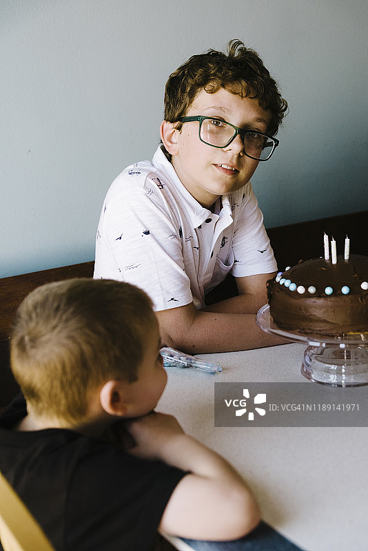 侄子帮忙庆祝青少年生日的巧克力蛋糕图片素材