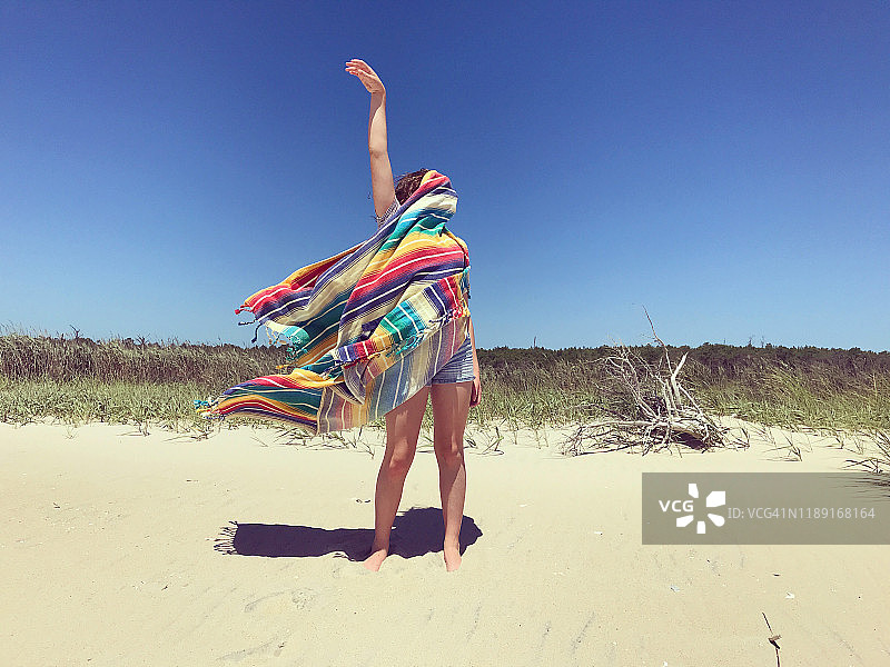 海滩上裹着毯子的女孩图片素材