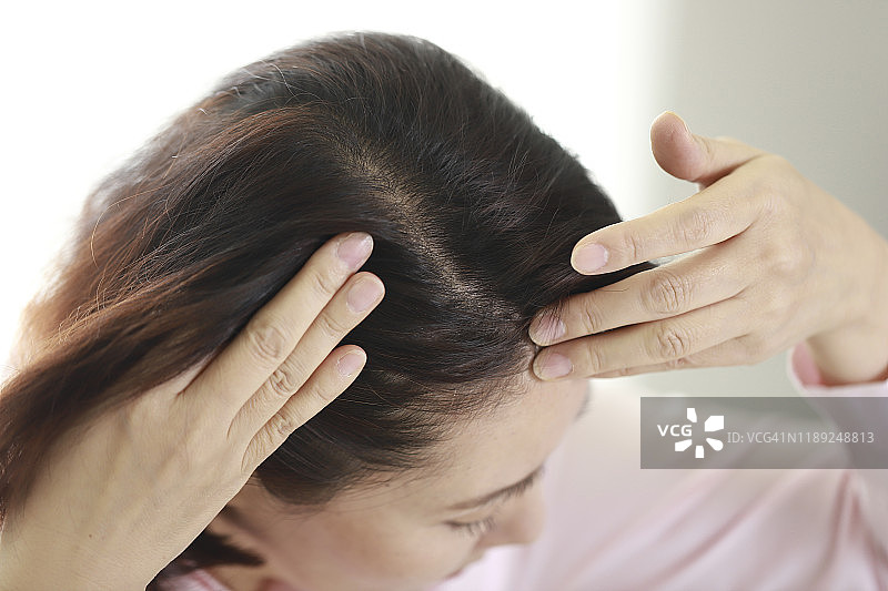 中年妇女检查头发特写图片素材