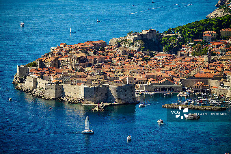 阳光明媚的一天，克罗地亚杜布罗夫尼克老城区的空中景色，有航海船只和停靠港图片素材