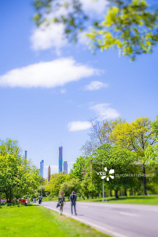 情侣在纽约中央公园的林荫道上散步图片素材