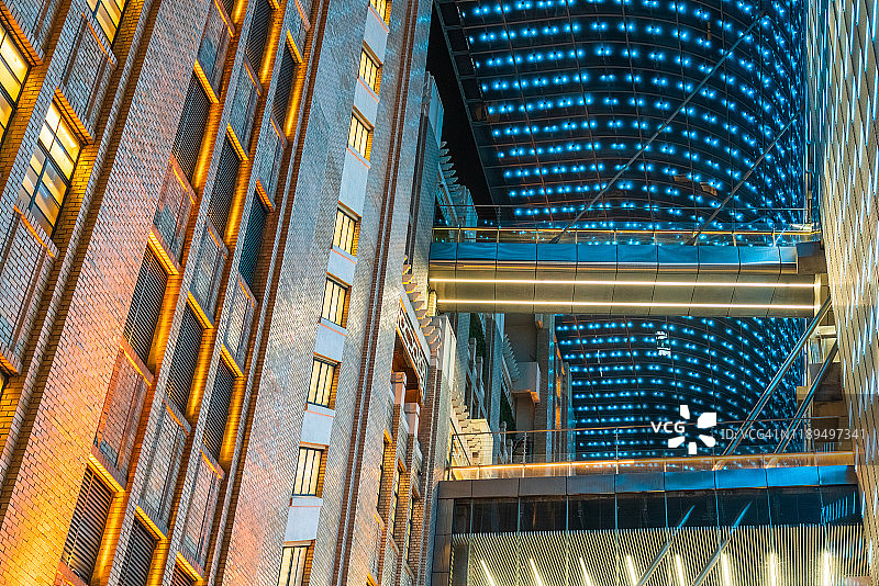 现代建筑的空中走廊，连接两栋建筑的走廊在夜间被点亮图片素材