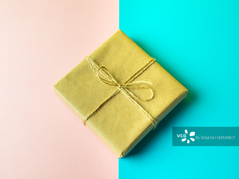 粉蓝背景下的棕色再生纸绳结礼品包装图片素材