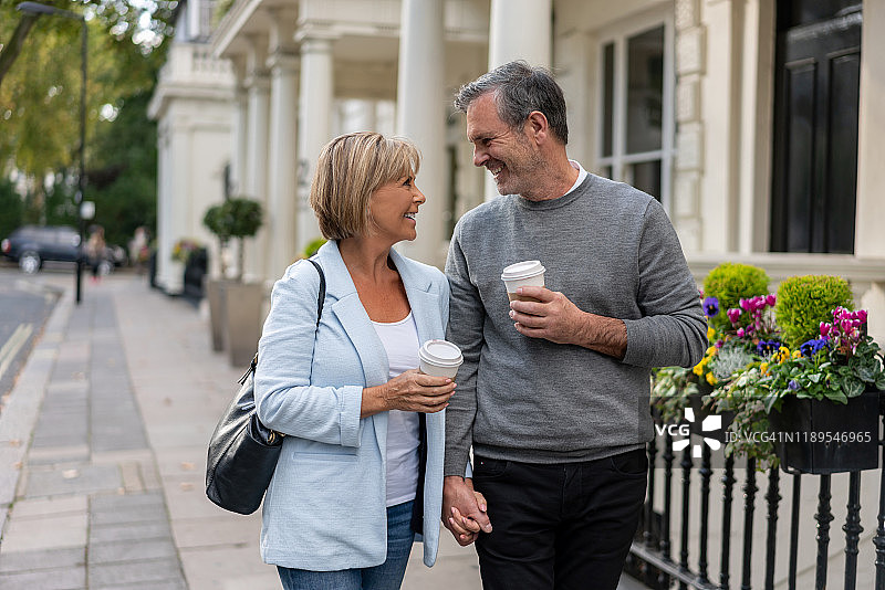 在街上手拿咖啡的恩爱夫妇图片素材