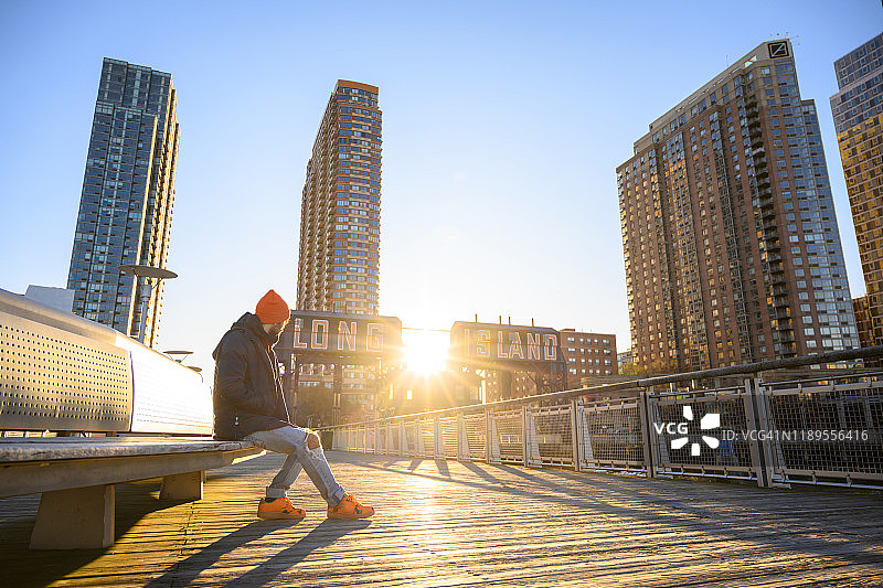 男子坐在长岛码头欣赏日出图片素材