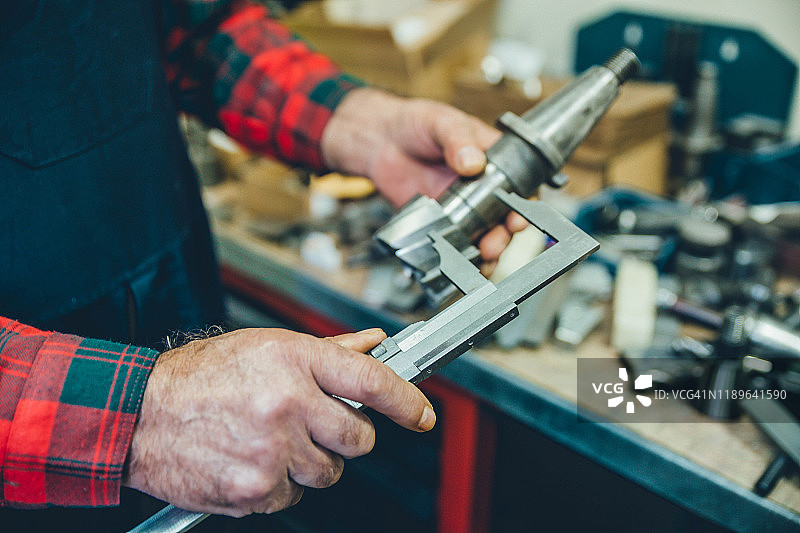 在家用卡尺测量的男人的手图片素材