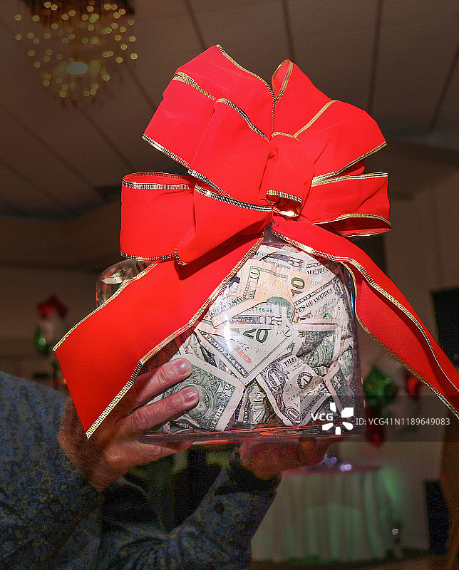 手举着一大罐钱的男人图片素材