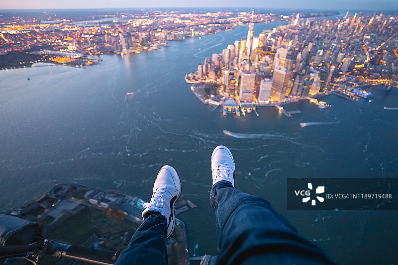 从直升机上俯瞰纽约市的人的脚的个人视角图片素材