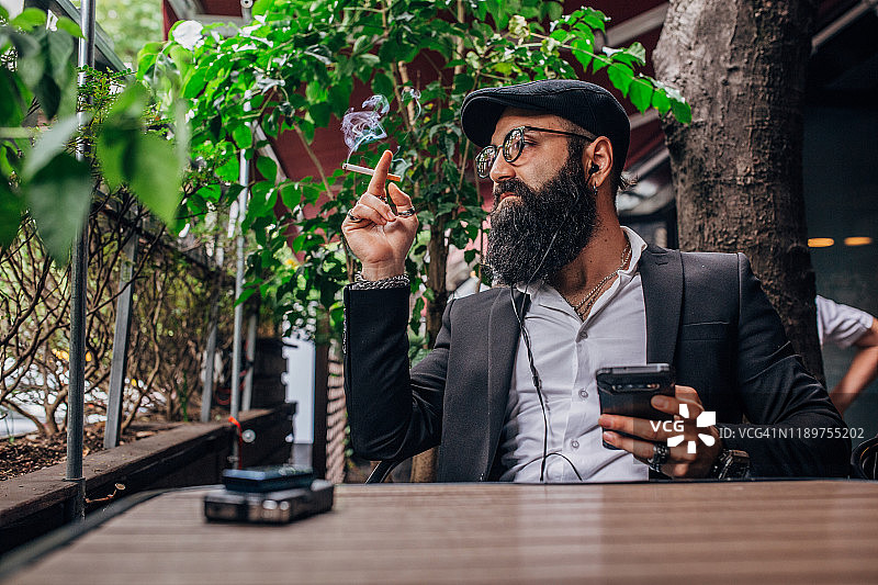 抽烟玩手机的时尚男人图片素材