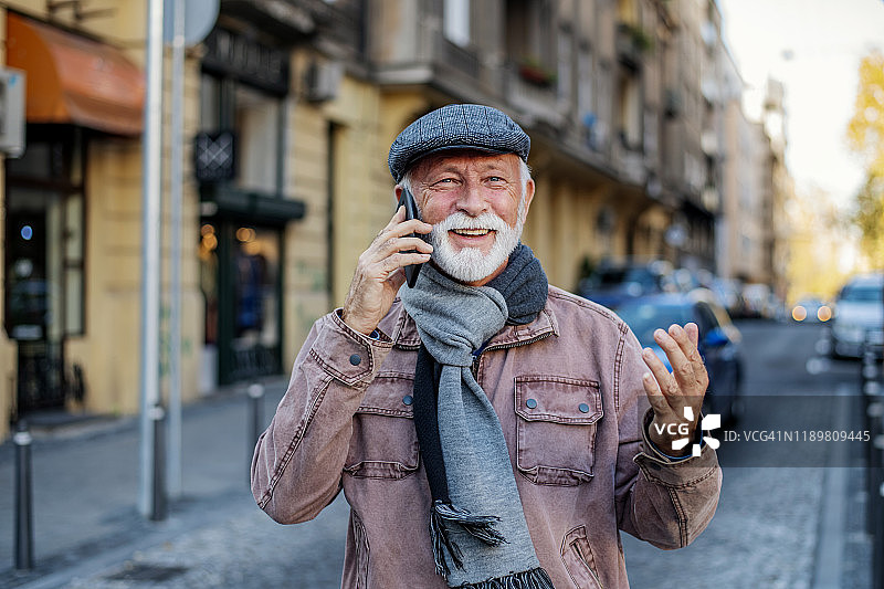 在户外用手机交谈的年长男人图片素材