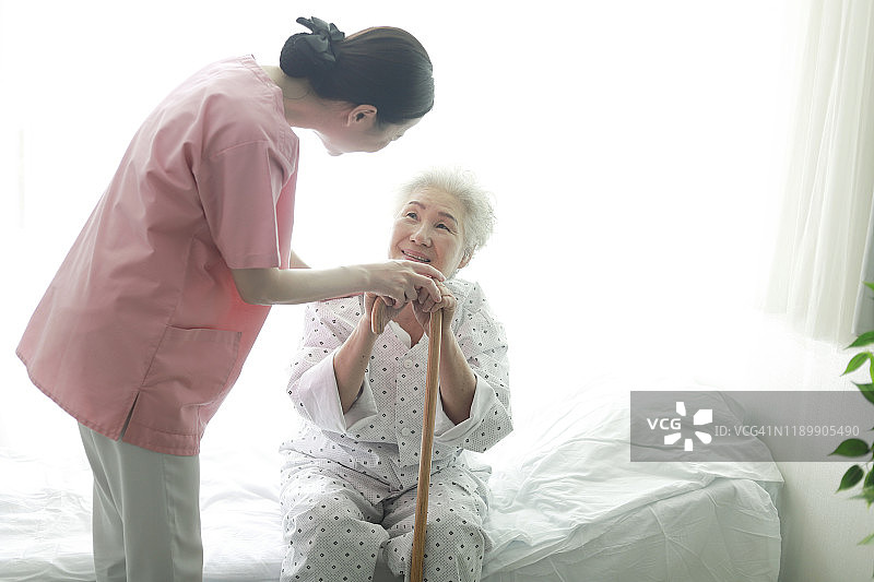 护士握着拄着拐杖的老年妇女的手图片素材