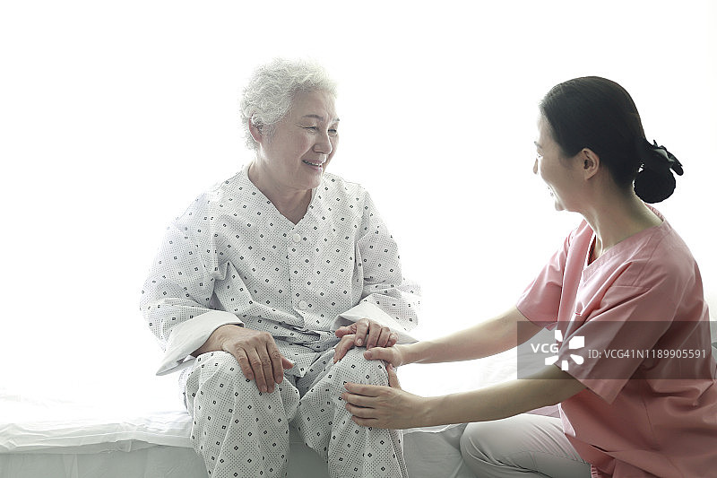 护士在医院病床上帮助年长女性图片素材