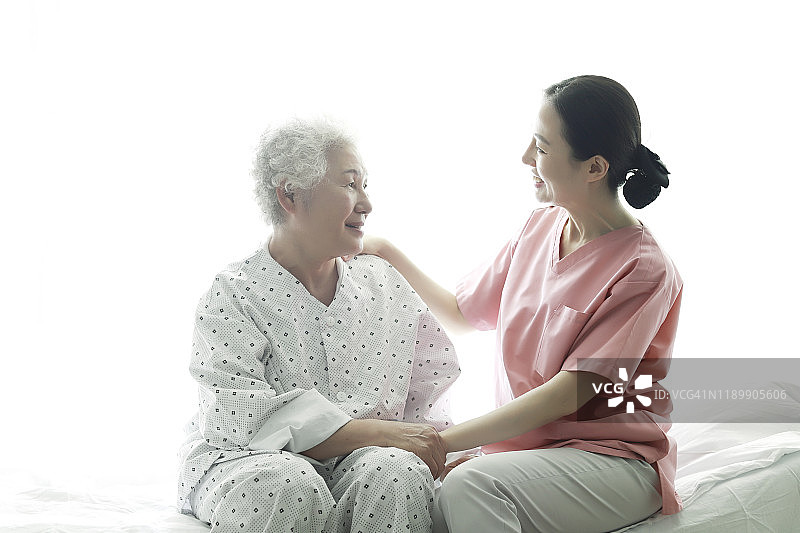护士在医院病床上帮助年长女性图片素材