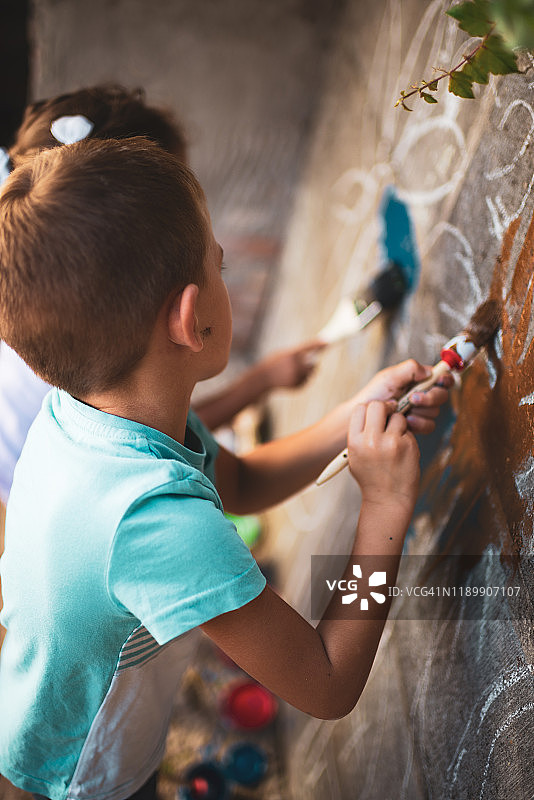 快乐的小朋友们在墙上绘画，玩得很开心图片素材