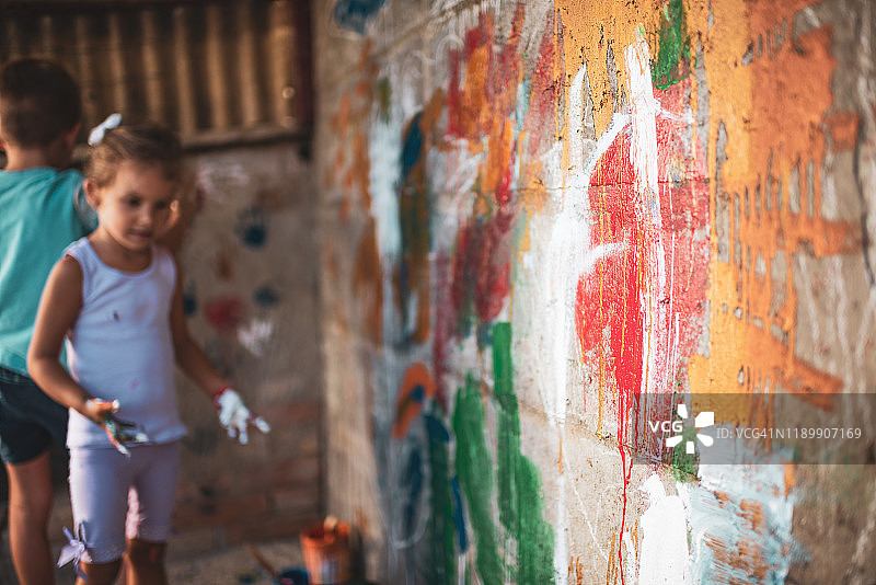快乐的小朋友们在墙上绘画，玩得很开心图片素材