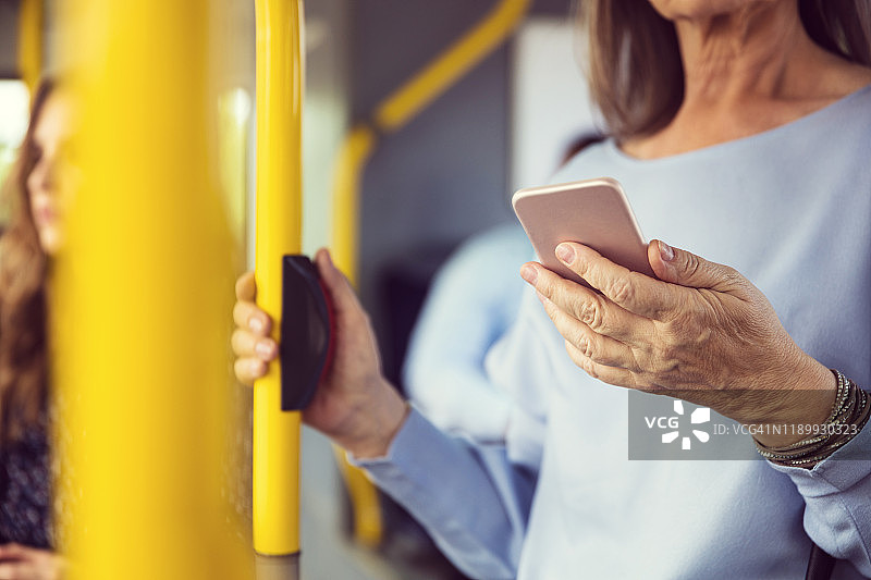 在公交车上使用智能手机的女人图片素材