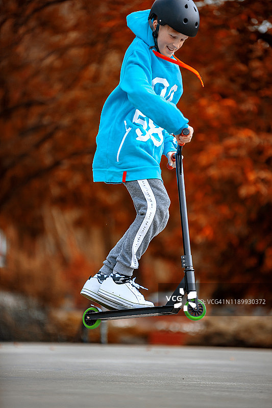 男孩玩滑板车飞在空中图片素材