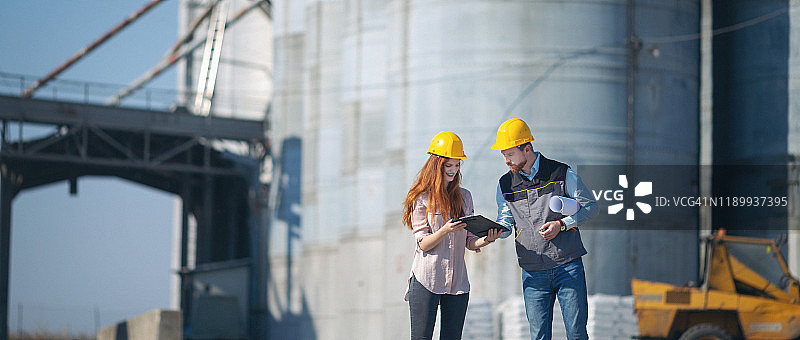 工程师在筒仓前交谈并制定计划图片素材