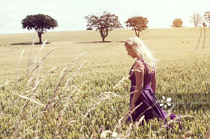金发女人在田野里行走图片素材