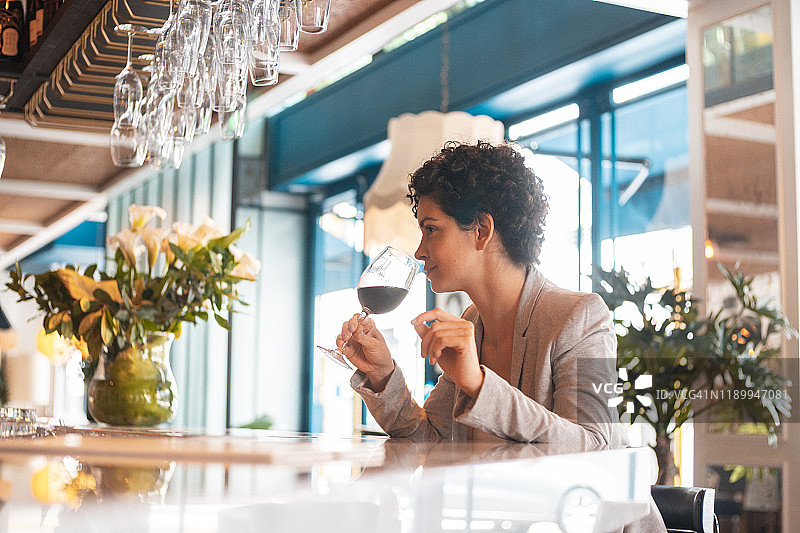 优雅女人在酒窖品尝葡萄酒图片素材