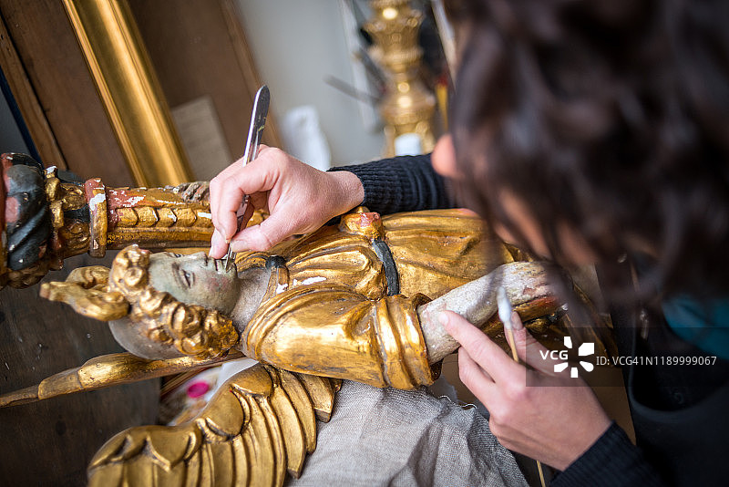 文物修复师修复金色天使雕像图片素材