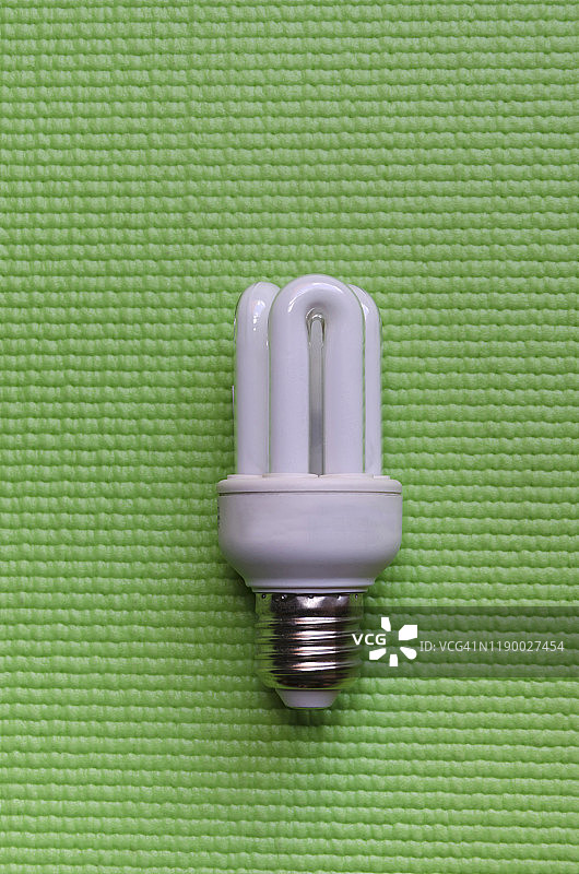 绿色背景上的节能荧光灯泡图片素材