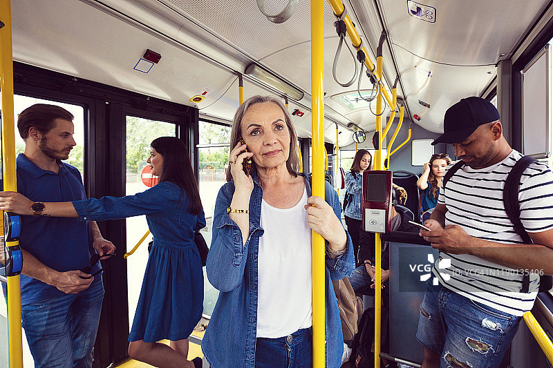 在公共汽车上用手机通话的女人图片素材