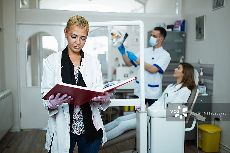 女牙医正在牙科诊所查看牙科记录图片素材