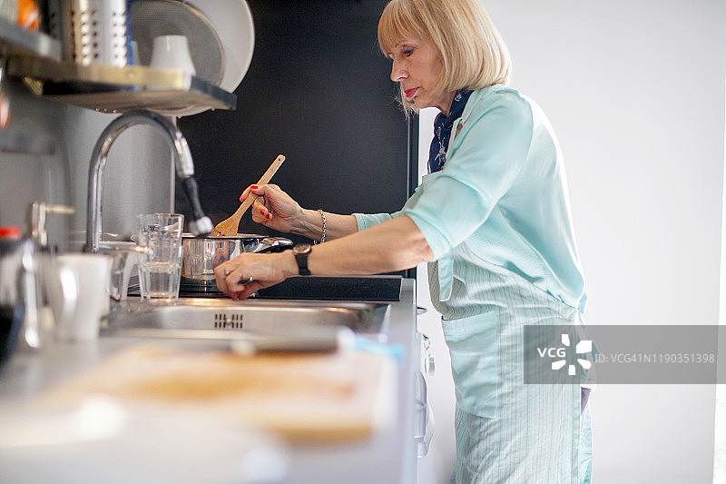 年长的女人搅拌番茄酱图片素材