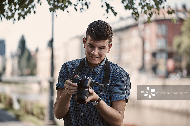 年轻摄影师查看相机中的照片图片素材