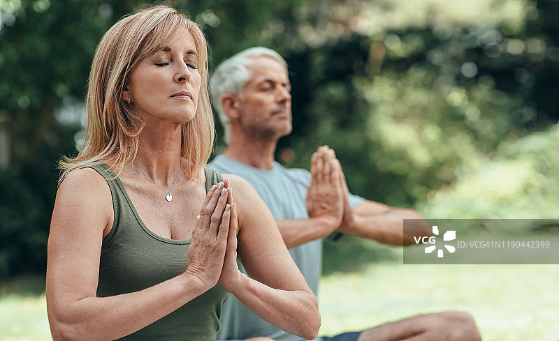 中年夫妇在户外一起练习瑜伽冥想图片素材