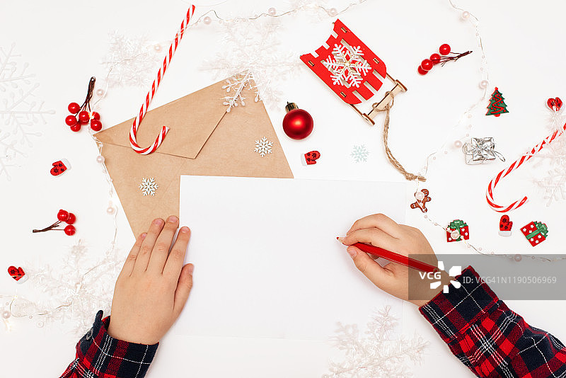 孩子给圣诞老人写信，木桌上有纸、铅笔和圣诞装饰，新年和圣诞节的概念，俯视图图片素材