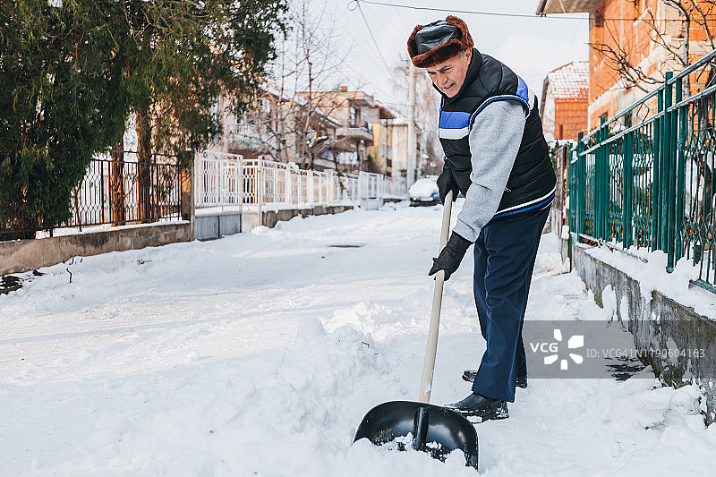 年长的男人在扫雪图片素材