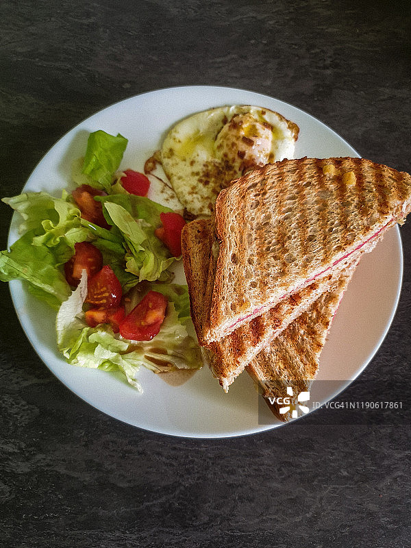 餐桌上的午餐（煎蛋、法式火腿奶酪三明治和沙拉）图片素材