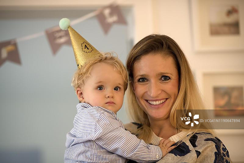 在母亲的怀里庆祝一周岁生日的幼儿，德国斯图加特图片素材