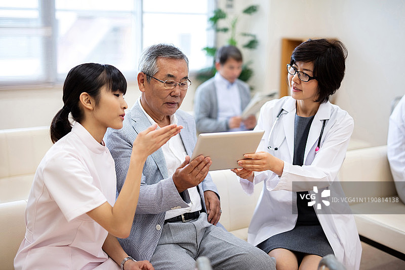 女医生和护士在医院通过电子病历向老年患者解释病情图片素材