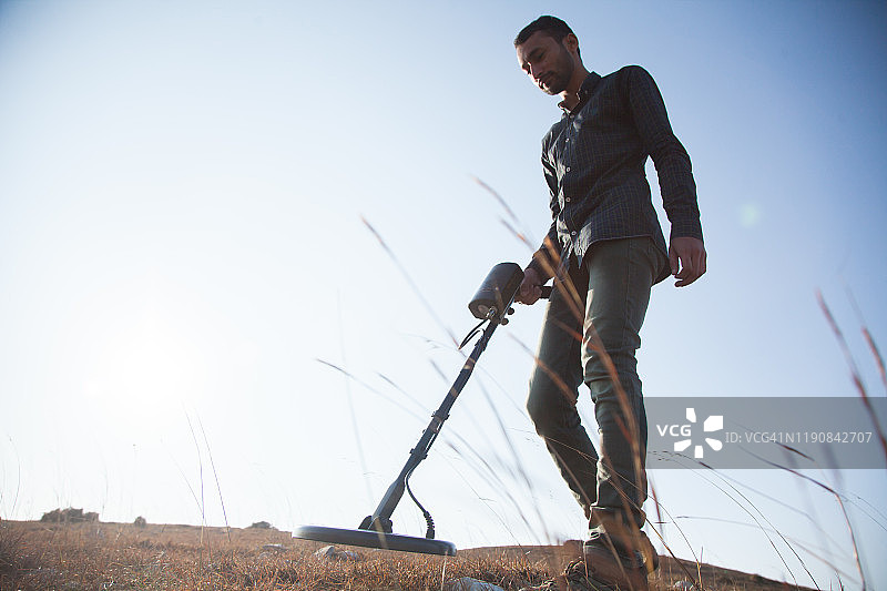 年轻人用金属探测器寻宝图片素材