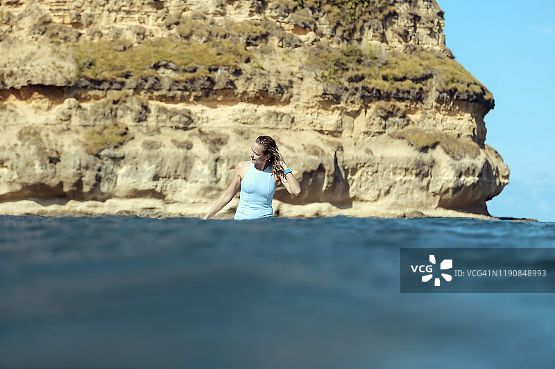 快乐的女人坐在海中的冲浪板上图片素材