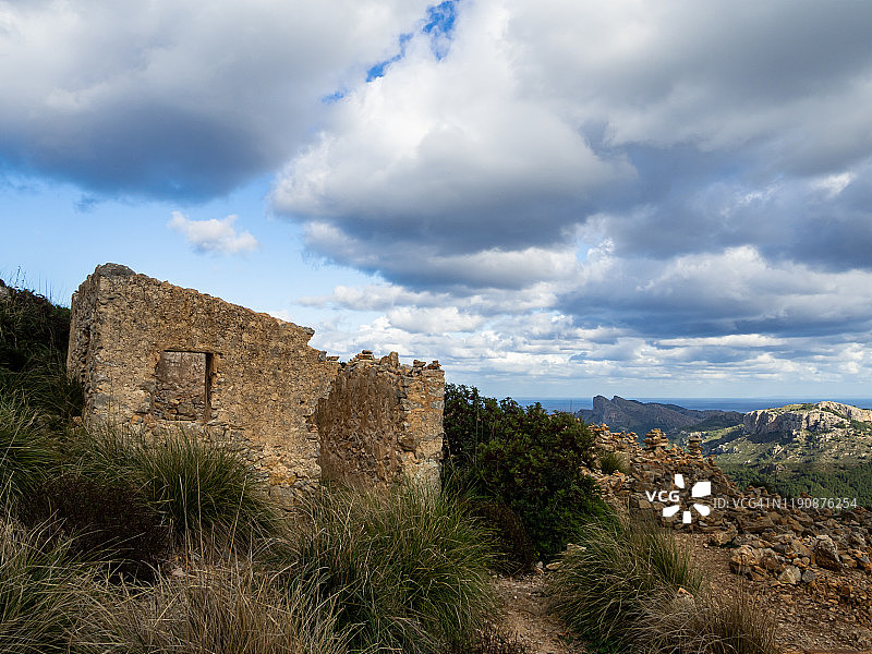 马略卡岛海岸，海边带石塔的废弃石头房子外立面图片素材