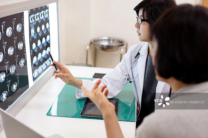 女医生在医院向年长病人讲解X光片图片素材