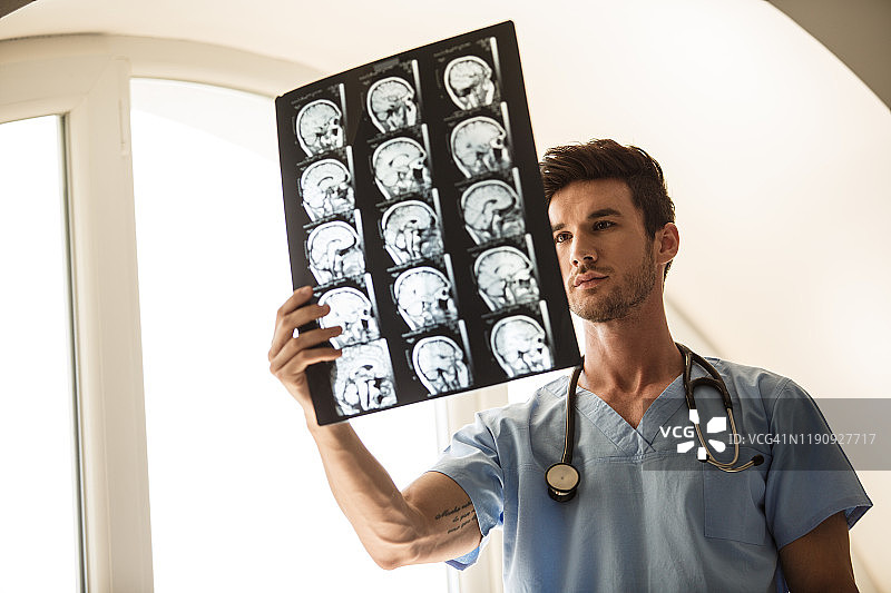 神经外科医生分析脑肿瘤患者的MRI扫描结果图片素材