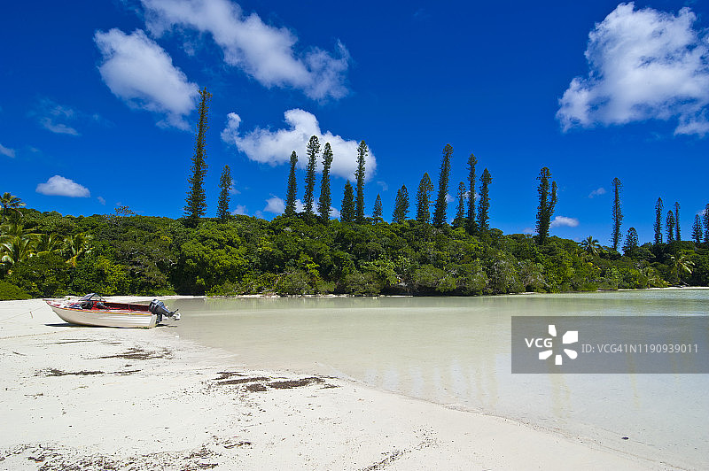 新喀里多尼亚美拉尼西亚，停靠在海滩树旁的船只图片素材