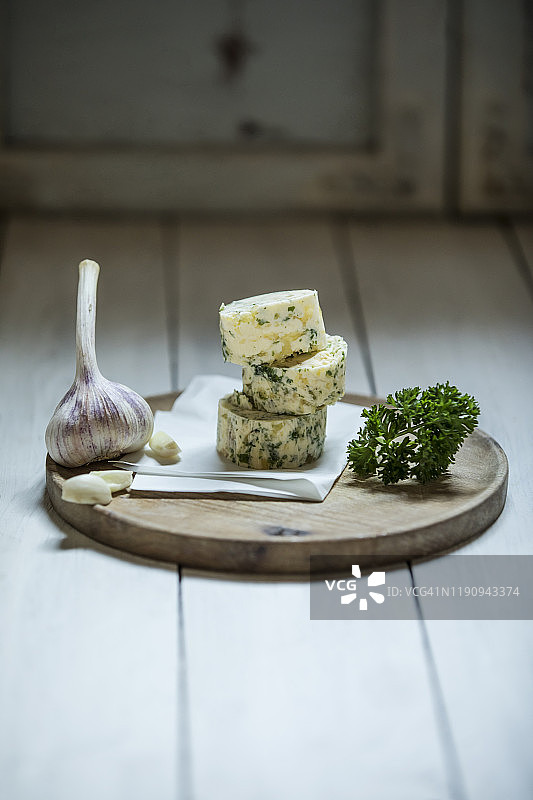 摄影棚木桌上的大蒜黄油与食材特写图片素材