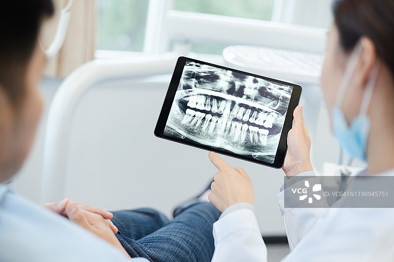 牙医向患者展示牙齿X光片图片素材