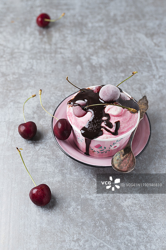 高角度拍摄的碗中盛放的樱桃冰淇淋和巧克力酱图片素材