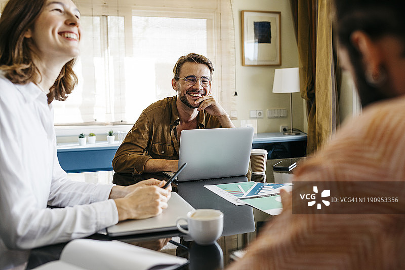 在家中一起在桌旁工作的快乐朋友们图片素材