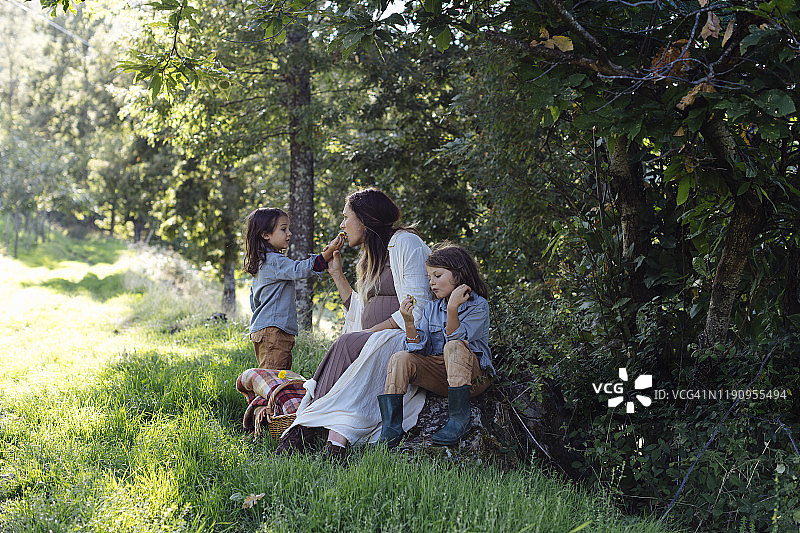 孕妇与两个孩子在乡下野餐图片素材