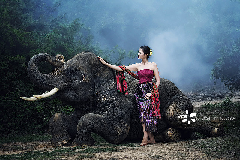 穿着传统服装、与大象合影的美女图片素材